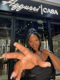 a woman is posing in front of a restaurant